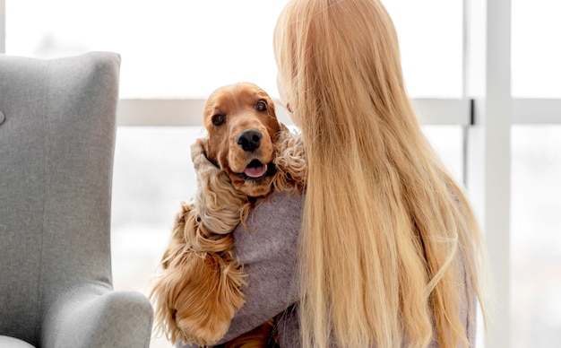 Engelse cocker spaniel hond met liefdevolle vrouw eigenaar zittend op de vloer thuis