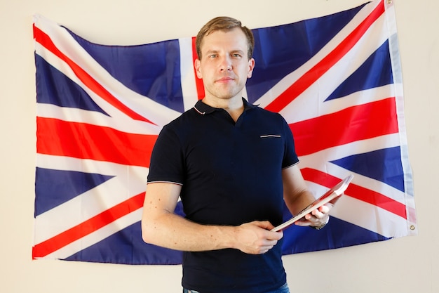 Engelse mannelijke student met de Britse vlag op de achtergrond Engels, leren, studeren.