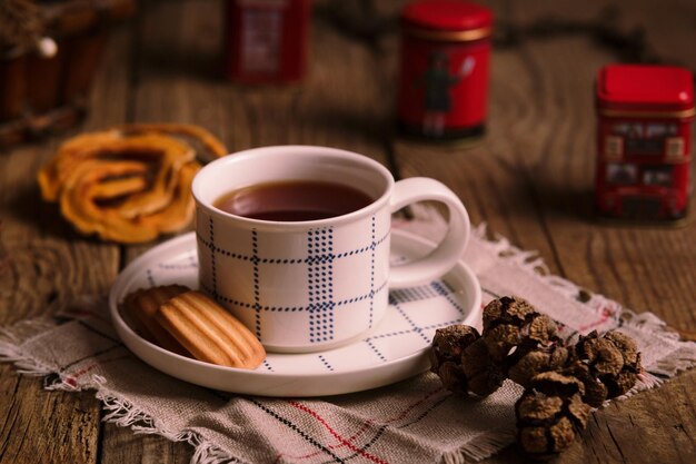 Engelse thee met koekjes op houten tafel, theetijd in de middag, rustieke stijl. Fotografie in donkere stemmingsstijl.