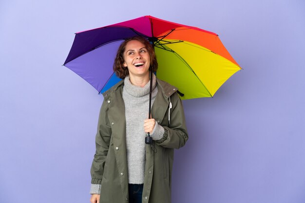 Engelse vrouw die een geïsoleerde paraplu houdt die een idee denkt terwijl hij omhoog kijkt