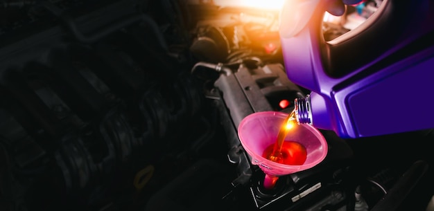 写真 engine oil poured into a funnel in the engine oil filler on a black background with copy space