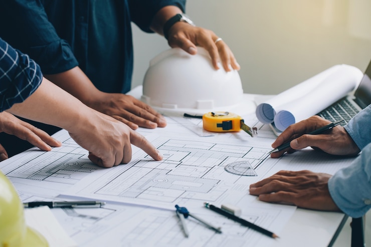 Photo engineer or architect meeting for project working with partner and checks construction blueprints