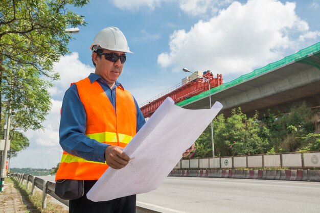 Engineer or Architect wear white Helmet working or reading Construction Plan 