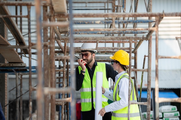 Engineer and architect working on the construction site doublechecking plans and process