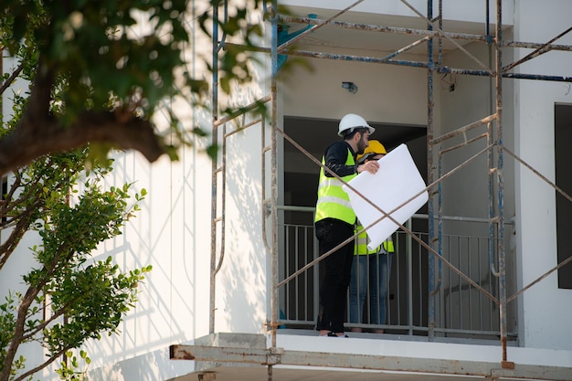 Foto ingegnere e architetto che lavorano sul cantiere ricontrollando piani e processi