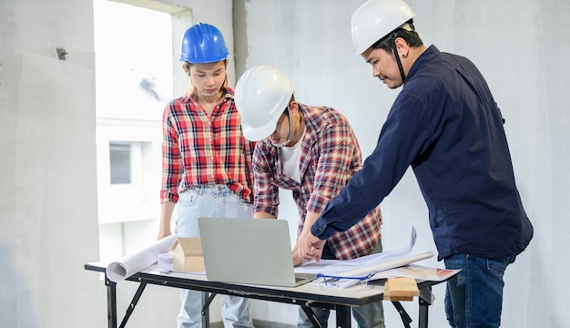 Ingegnere e architetti che lavorano e discutono in cantiere. ispezione del proprietario al progetto del villaggio e alla costruzione della proprietà