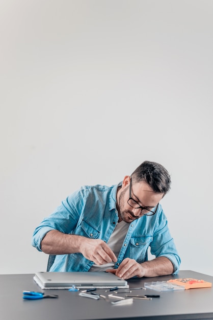 Engineer assembling laptop computer.