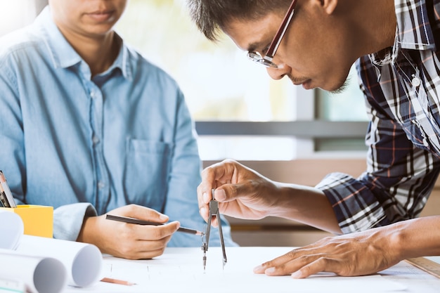 Engineer bearded male working with architect female in workspace together