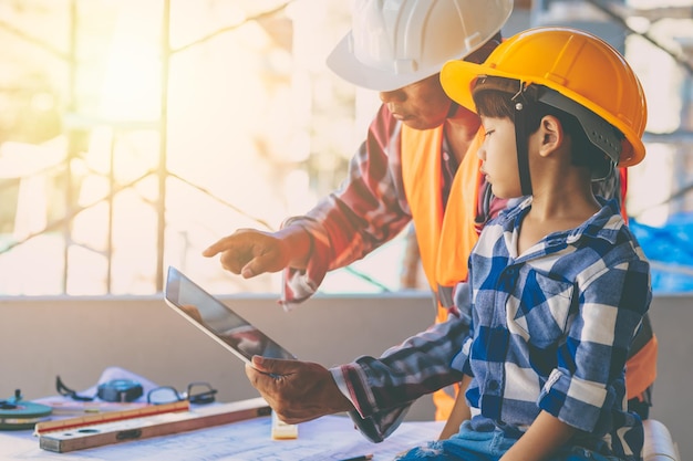 Ingegnere costruttore famiglia padre giorno gioco di ruolo insegnamento figlio bambino al cantiere