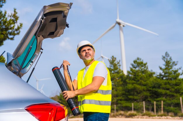 Photo engineer carrying a drawing tube in a wind energy park