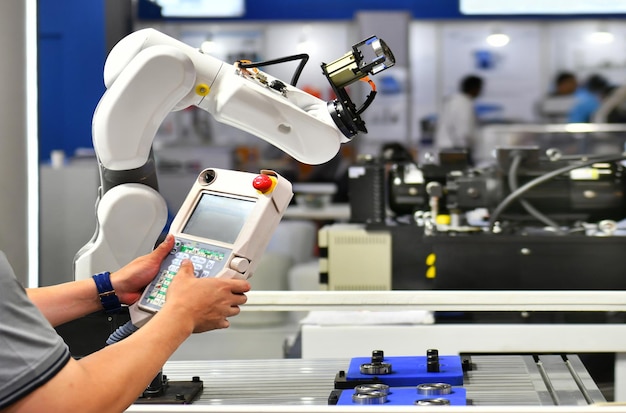 Инженер проверяет и контролирует автоматизацию робота-манипулятора для упаковки автомобильных подшипников