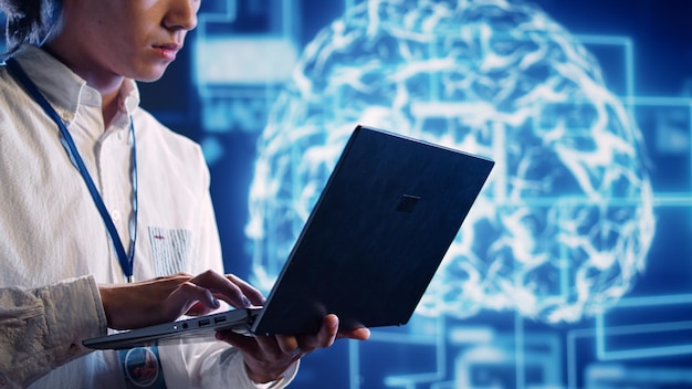 Engineer in cloud computing business uses artificial intelligence computing simulating human brain thought processes. Admin performing operations on laptop with AI machine learning algorithms