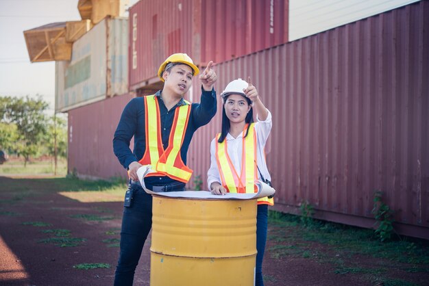 Engineer Concept: Young Engineers working with blueprint at the construction site