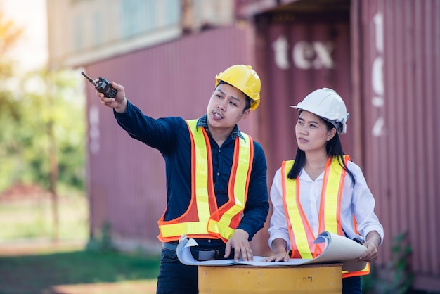 Engineer Concept: Young Engineers working with blueprint at the construction site