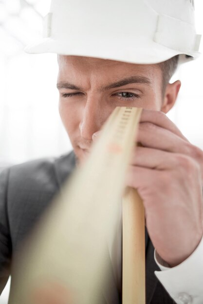 Engineer in construction helmet with tape measure Isolated Close Up