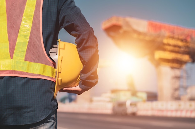 Engineer construction holding hard hat building structure background