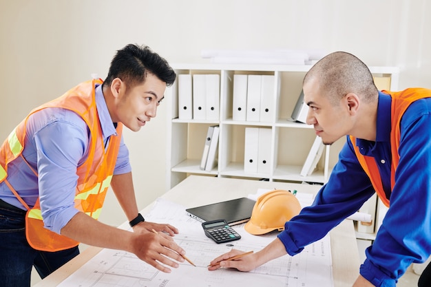 Engineer and contractor discussing blueprint