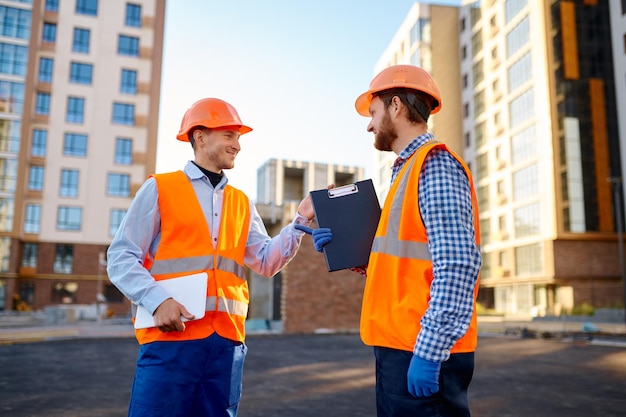 Engineer and contractor having brief meeting dealing with next building phase at construction site