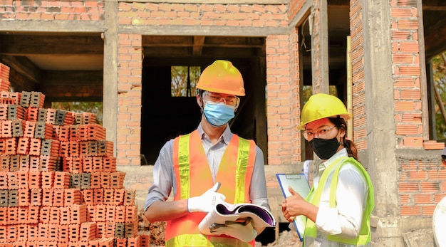 Engineer contractor team meeting work safety plan industry project and check design at the construction building site.