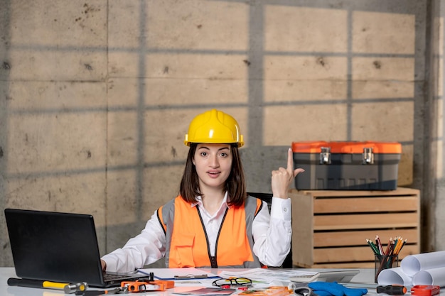 Foto ingegnere carino giovane ragazza bruna intelligente lavoratore civile in casco e giubbotto che ha un'idea