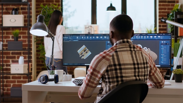 Engineer designs a turbine in an industrial office using CAD software