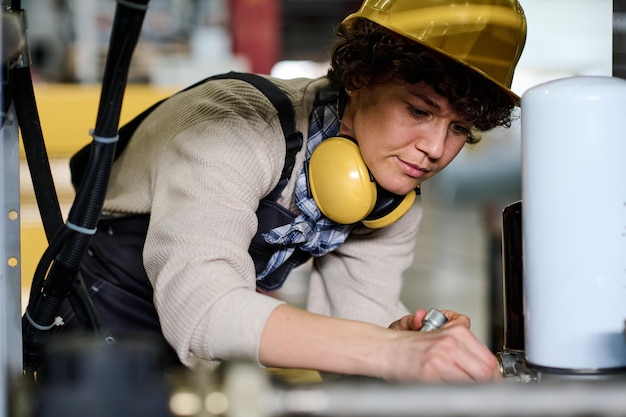 Photo engineer examining or assembling new industrial equipment in factory