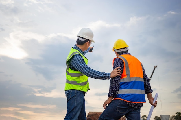 Engineer and foreman worker checking project at building construction site