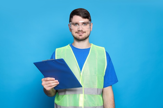 Engineer in glasses with folder in hand on blue background