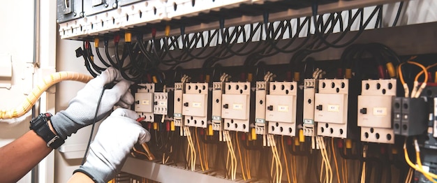 Engineer hand holding AC voltmeter checking electric current voltage at circuit breaker terminal