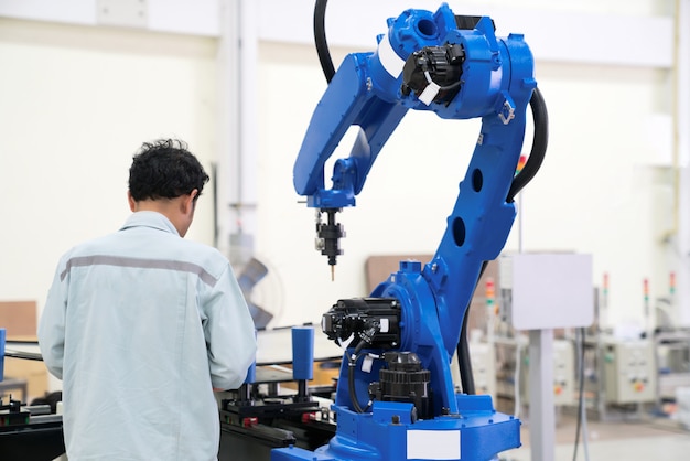 Engineer hand using tablet, heavy automation robot arm machine in smart factory industrial