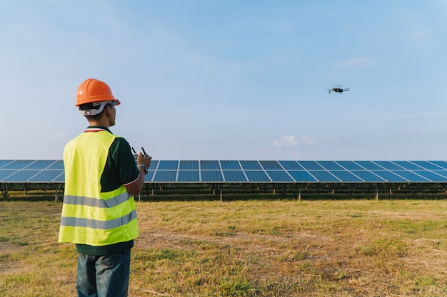 太陽光発電所でドローンによるソーラーパネルの検査とチェックを行うエンジニア