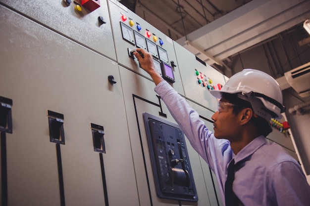 L'ingegnere controlla la tensione o la corrente dal voltmetro nel pannello di controllo della centrale elettrica.