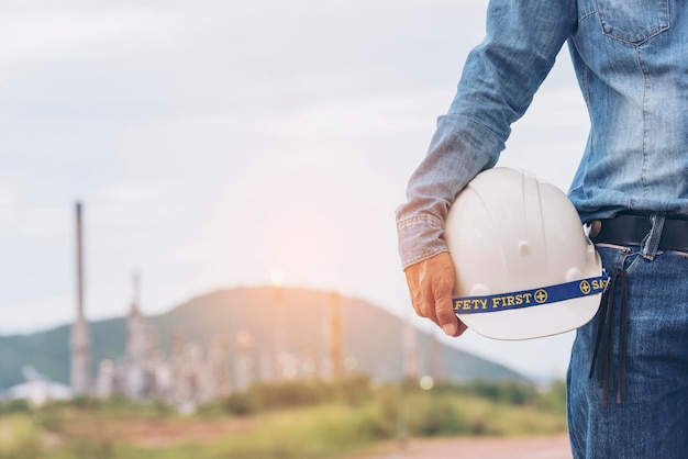 Engineer man hands holding hardhat white work helmet hard hat for Civil Construction Engineering Construction engineer man in safety suit hold white work helmet hard hat on hands at Construction Site