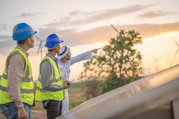 エンジニアの男性は、電子デバイスによって太陽電池パネルまたは太陽電池セルの建設を検査します タワーの屋根に取り組んでいるグリーン電力工場労働者の産業用再生可能エネルギー