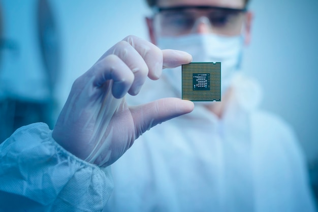 Photo engineer man  in sterile suit is holding microchip with symbols in modern design factory  , futuristic and artificial intelligence concept