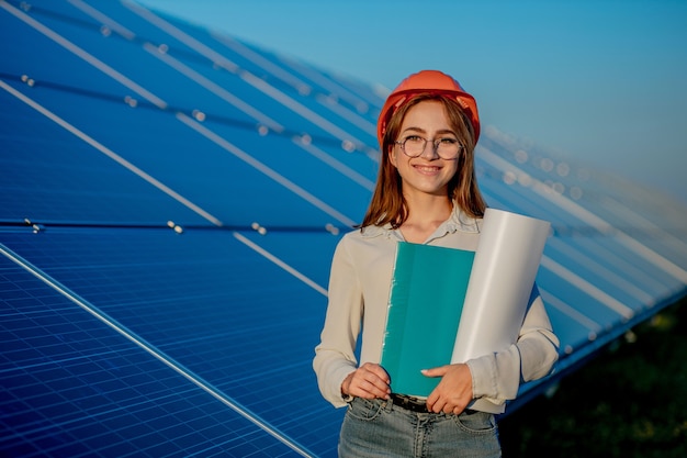 Engineer in orange helmet smiling and holding folder