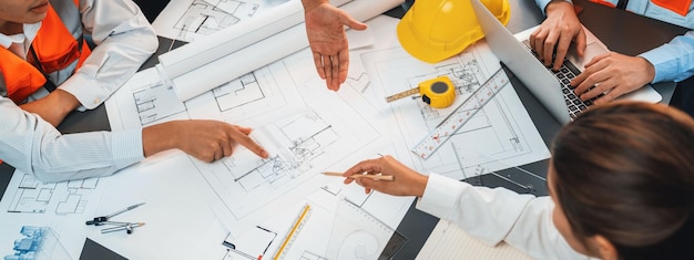 Engineer partner drawing and working on blueprint design together on office table for architectural building construction project Architect drafting interior blueprint layout Insight