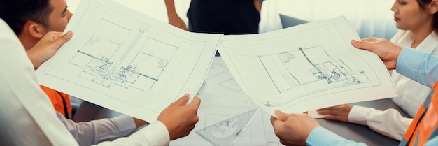 Engineer partner drawing and working on blueprint design together on office table for architectural building construction project Architect drafting interior blueprint layout Insight