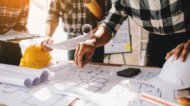 Engineer people meeting working in modern office for discussing engineering hands of engineer working on blueprint construction concept