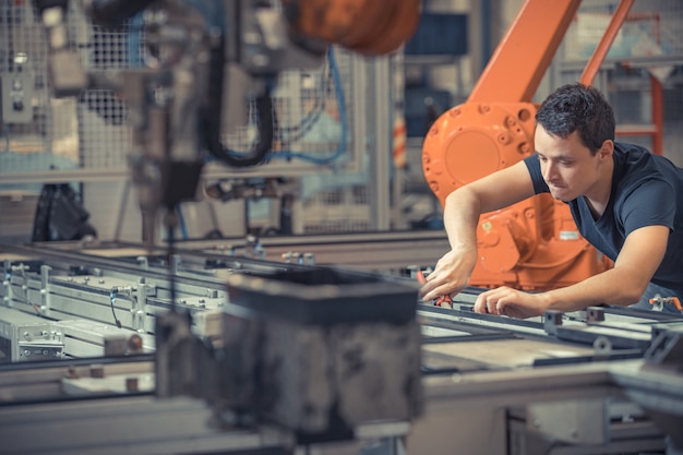 Engineer performs maintenance of industrial robot in a factory