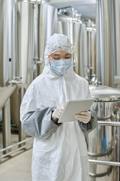 Engineer in protective wear working on tablet pc