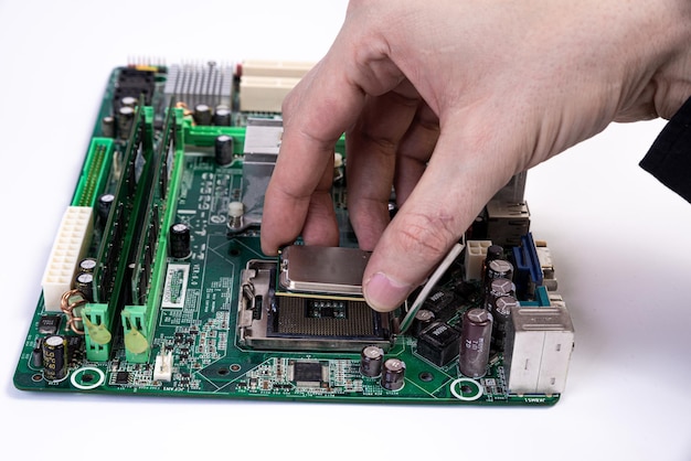 Engineer repairman holding hands in black gloves chip processor CPU to insert into the socket of the computer motherboard The concept of technology hardware in the neon light