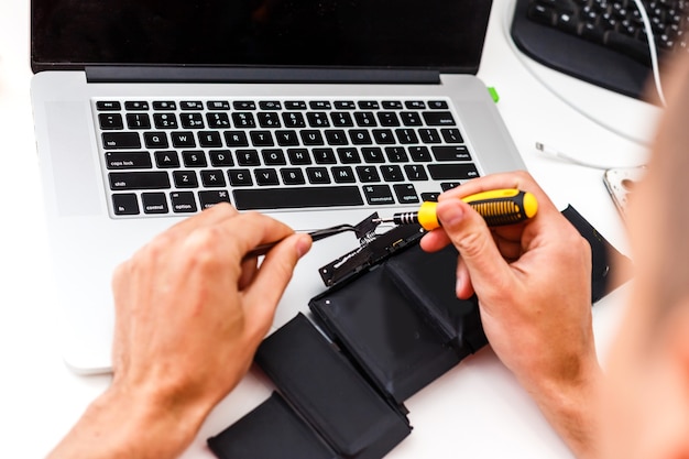 The engineer repairs the laptop (pc, computer) and the motherboard. Installs the equipment (cpu)