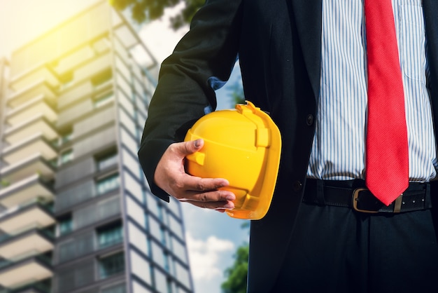 Engineer in suit holding helmet