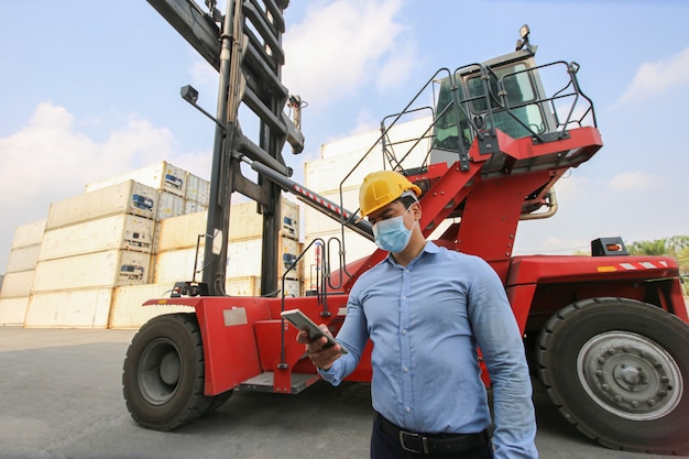 Engineer or supervisor checking and control loading Containers box from Cargo at harbor.