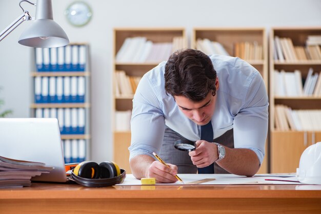 Ingegnere supervisore che lavora su disegni in ufficio