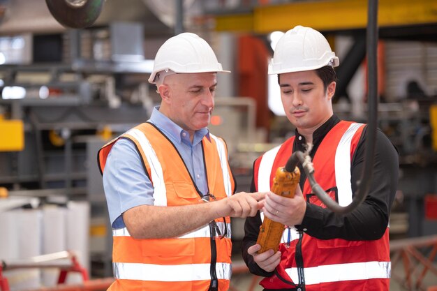 Engineer team worker teaching help talking production machine Industry and work in factory staff operate control heavy machine in factory