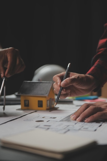 Riunione di lavoro di squadra dell'ingegnere disegno di lavoro sulla riunione di progetto per il progetto di lavoro con il partner sulla costruzione di modelli e strumenti di ingegneria nel sito di lavoro concetto di costruzione e struttura