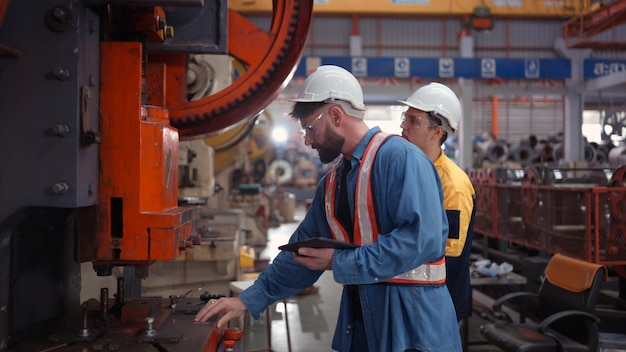 Engineer and technician discussing machinery in factory to plan inspection maintenance