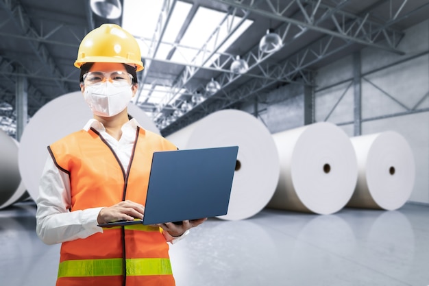 Engineer or technician work in paper factory with computer notebook